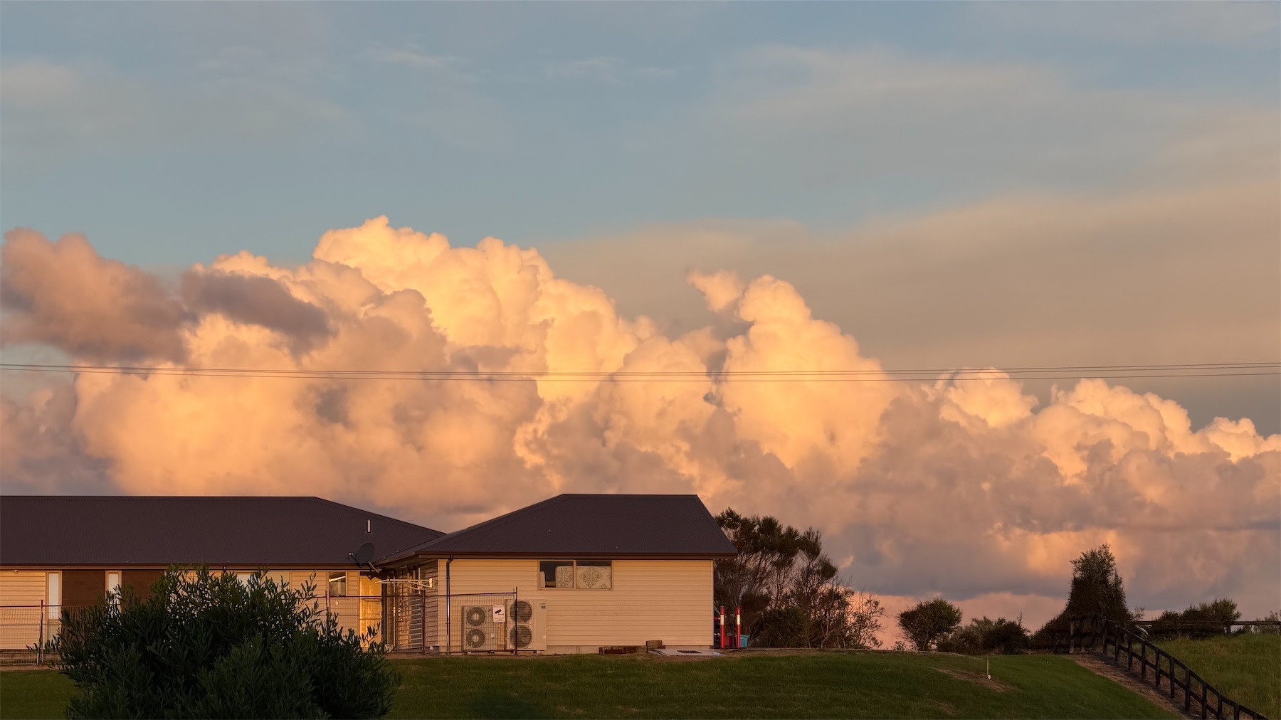 Towering white clouds tinged with late sun. 