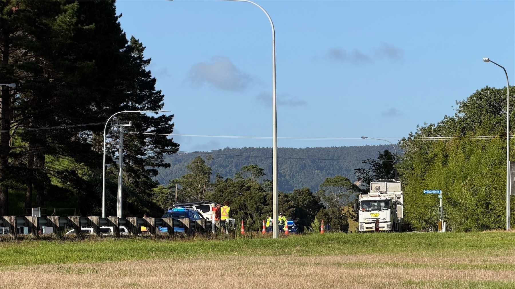A distant view of police cars and trafic management at the crash scene. 