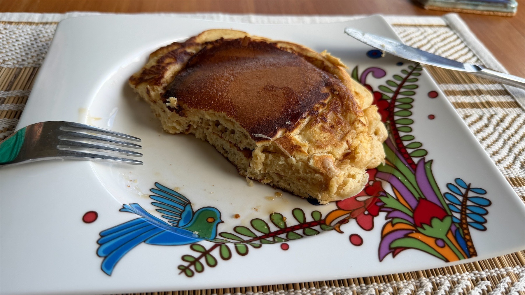 Partly eaten pair of pancakes on a plate. 