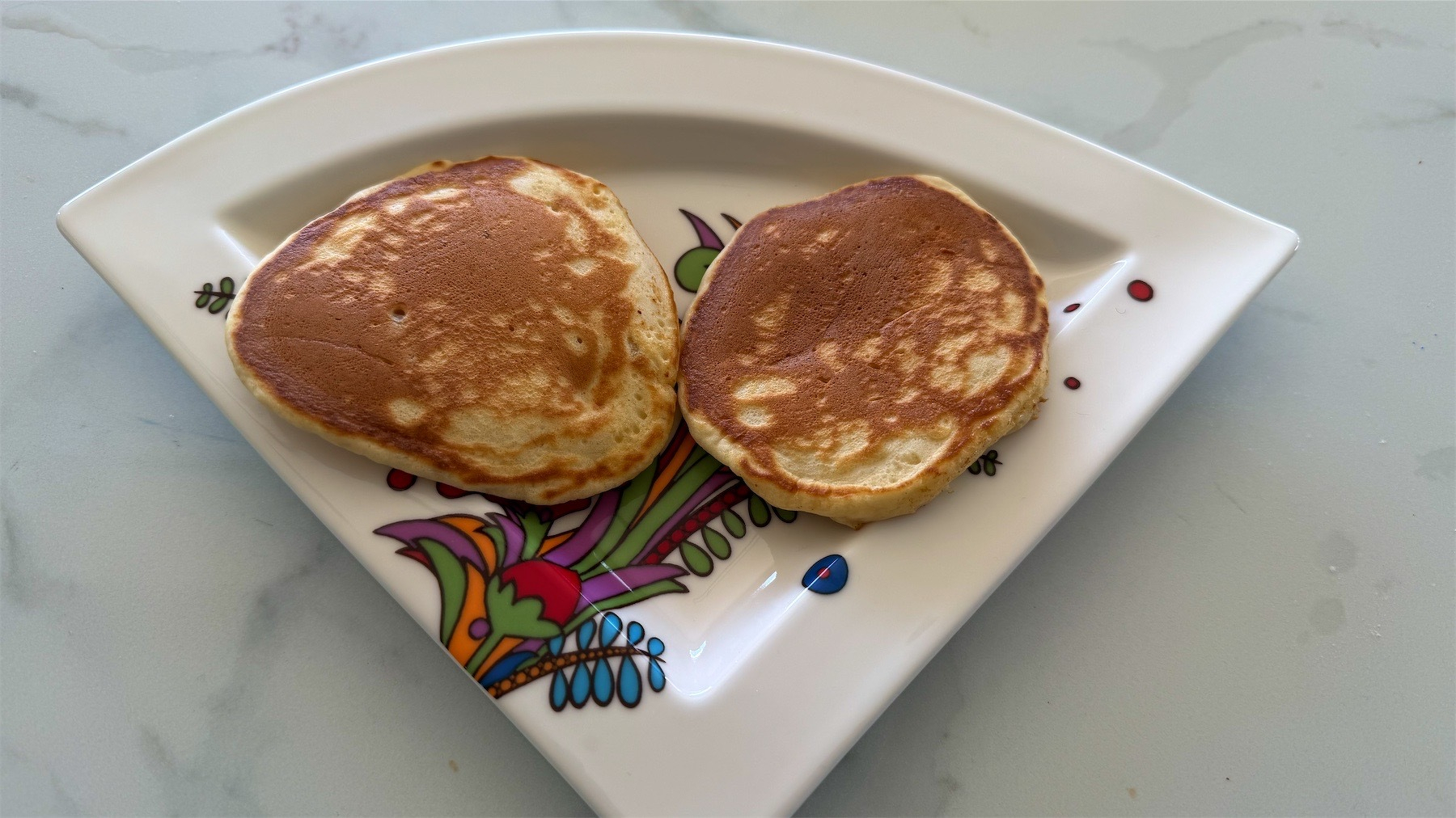 Two pikelets on a fancy plate.