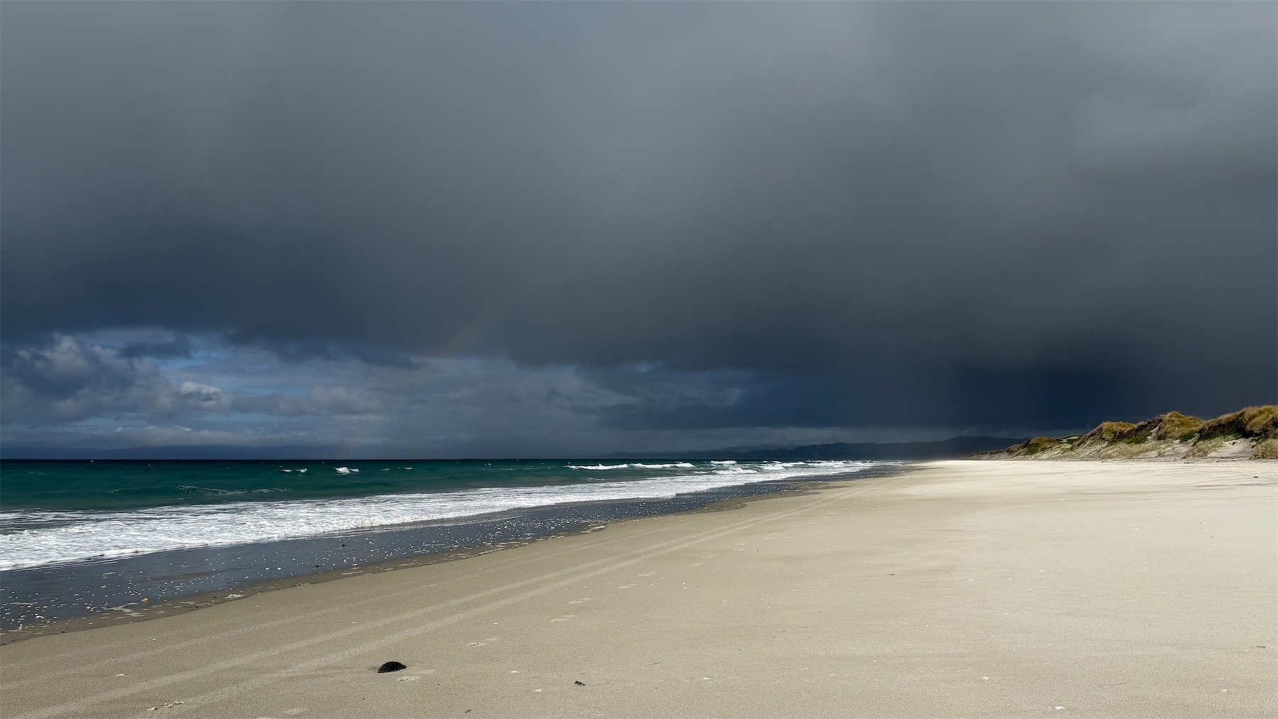 Dark sky white sand rainbow.