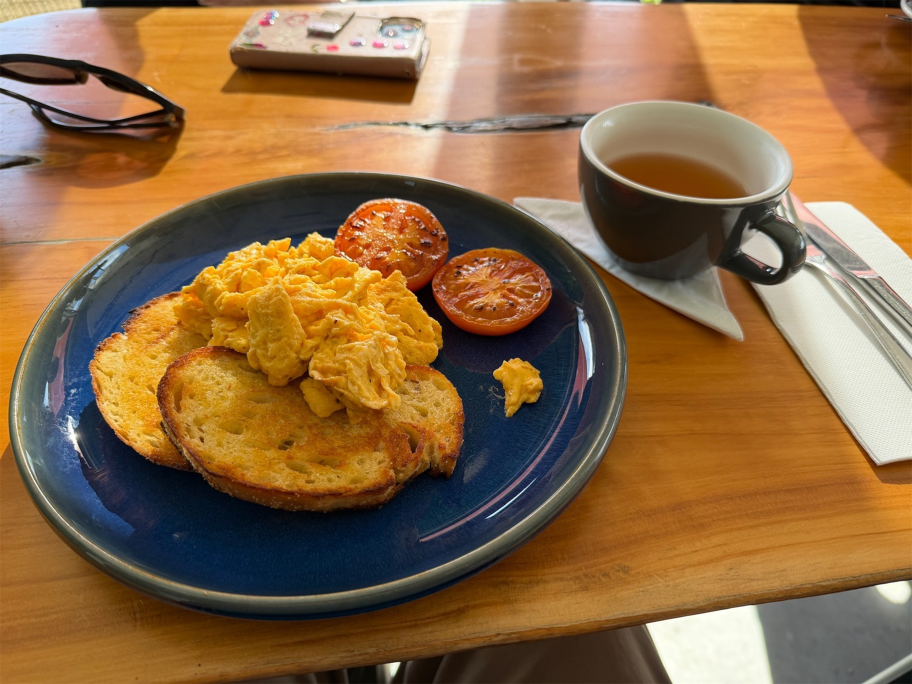 Plate of eggs, with cup of tea beside.