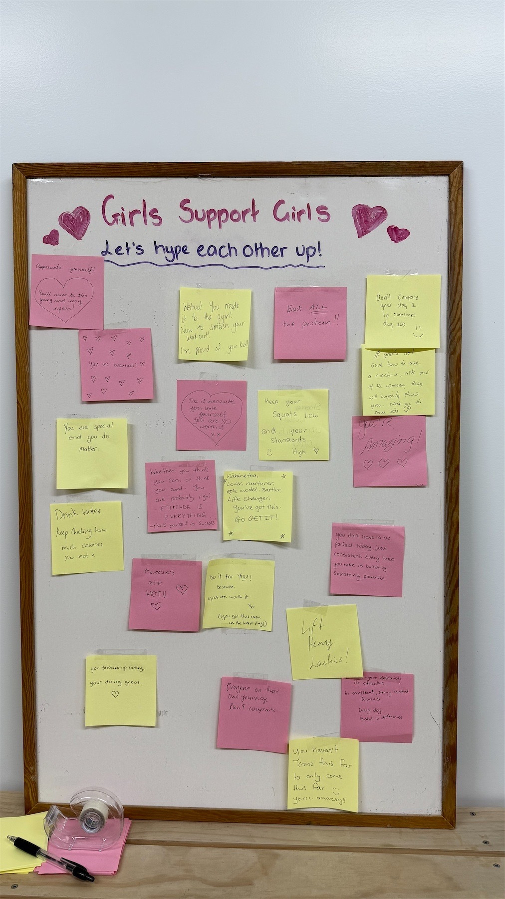 A small noticeboard headed Girls Support Girls contains many sticky notes with inspirational messages. 
