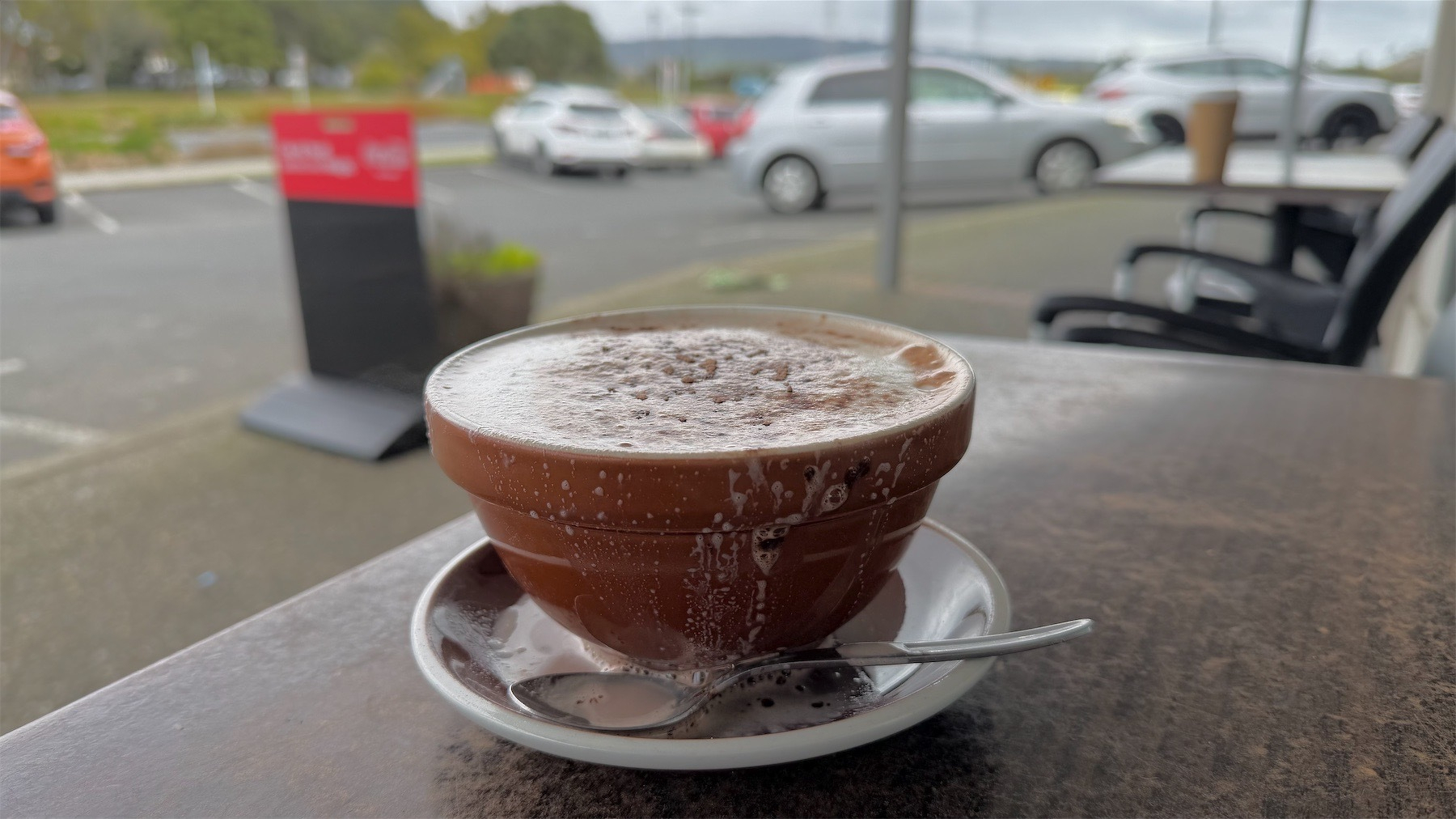 Hot chocolate with car park in the background.