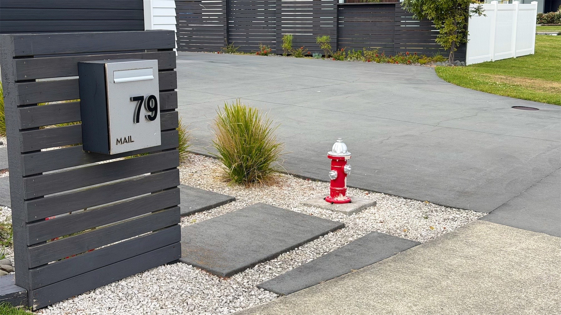 Miniature red fire hydrant near a letterbox.