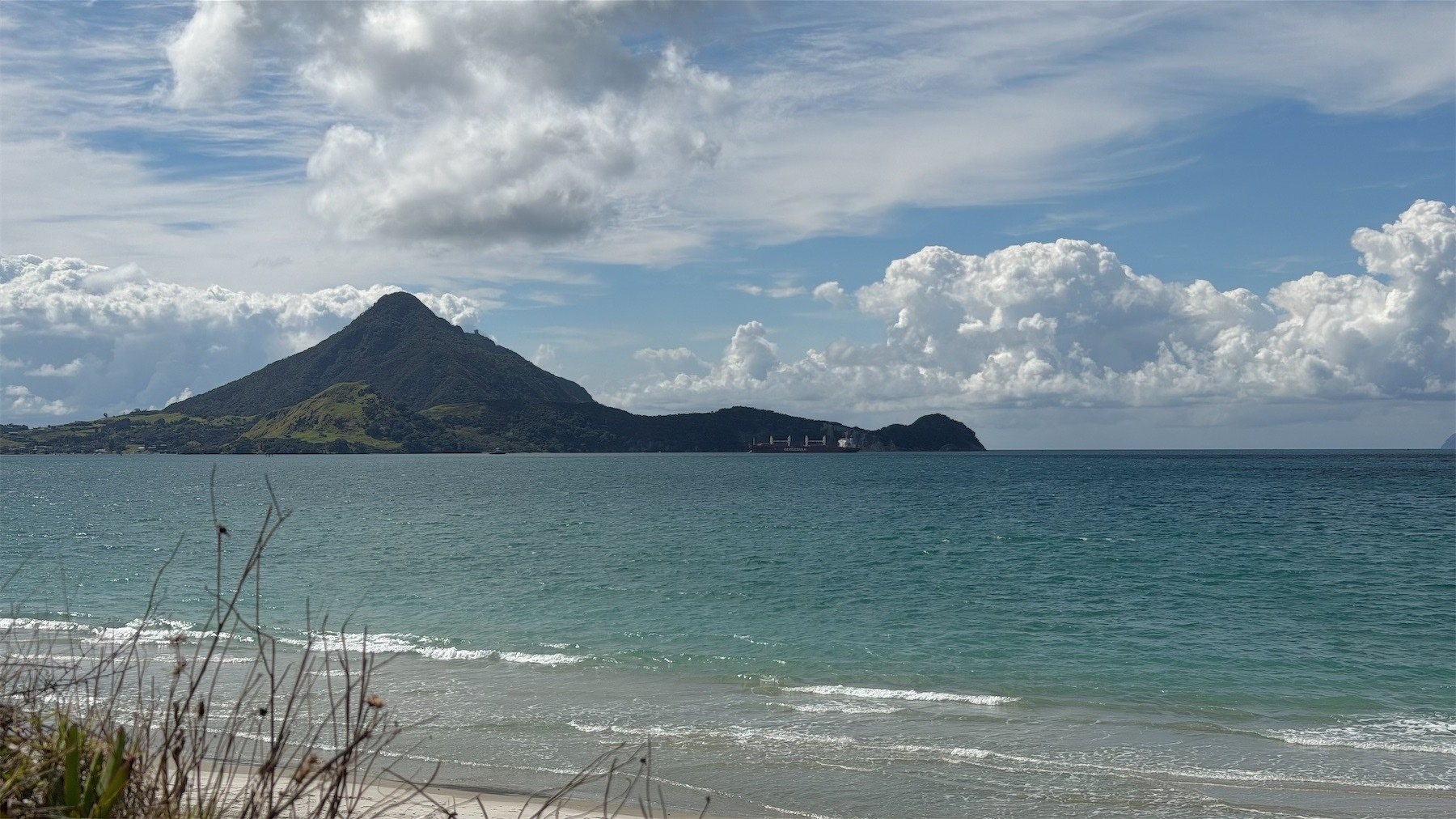 Empty log ship in front of a green hill in the background.