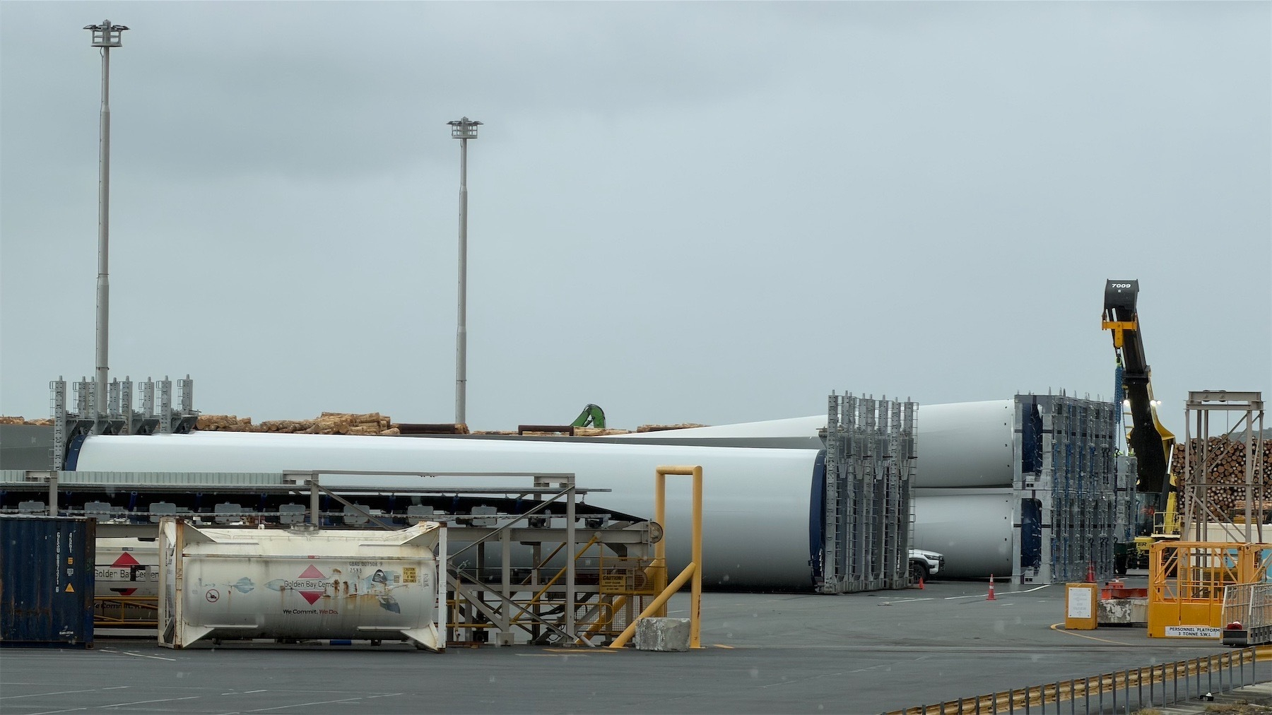 Huge white cylinders lying on the ground at the port. 