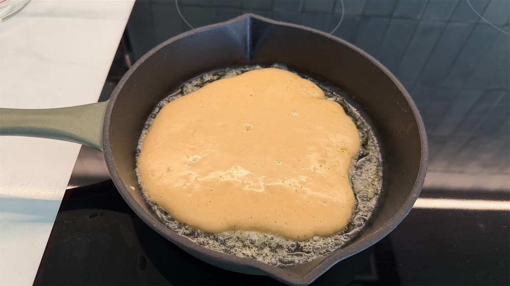 Pancake cooking in a cast iron frypan.