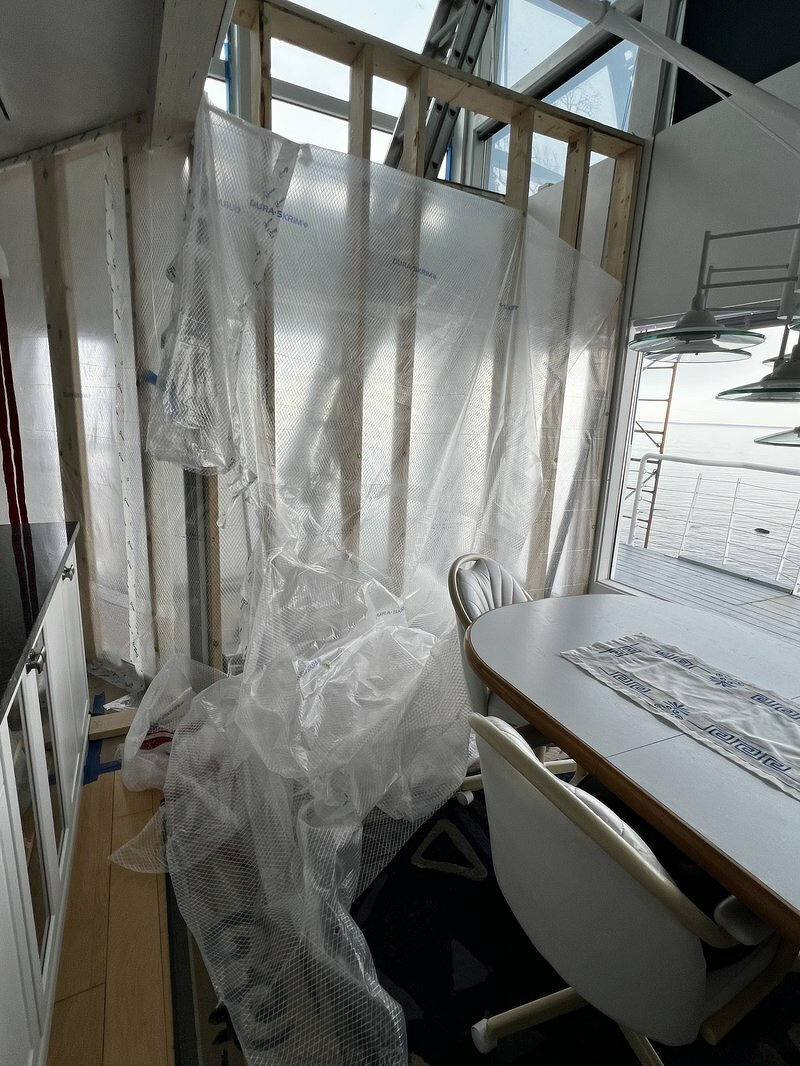 Interior with plastic sheeting over wall framing