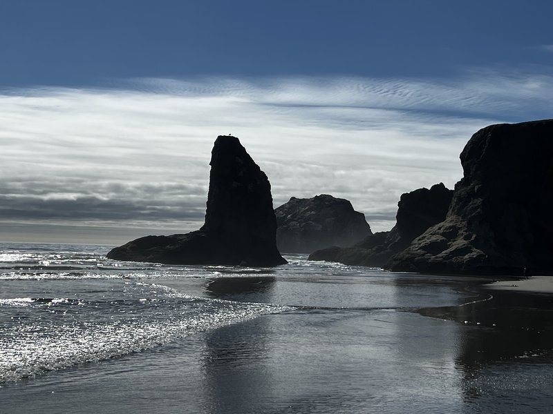Dark sea stacks silhouetted against the incoming tide