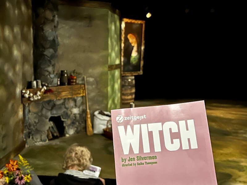 The program for Witch by Jen Silverman held up in front of the Zeitgeist set