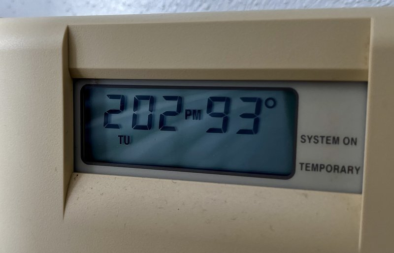 A thermostat reading 93 degrees at 2:02 PM