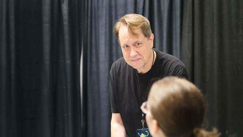 Justin leaning across the table toward a player during a Mothership session at Excalibur Con