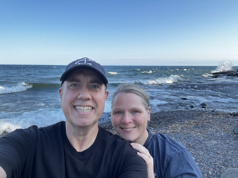 Justin and Jody taking a selfie on the cobble beach at Stony Point with Lake Superior behind them