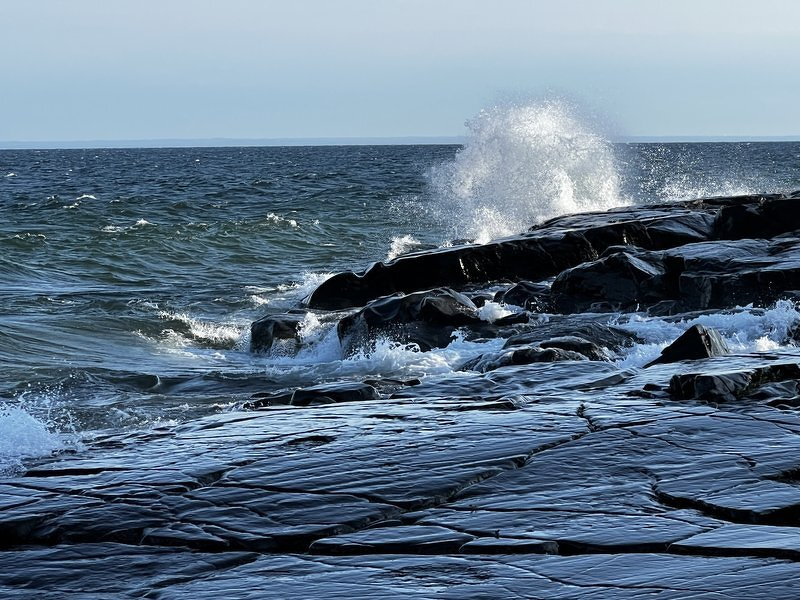 A larger wave exploding upward off the rocks at Stony Point