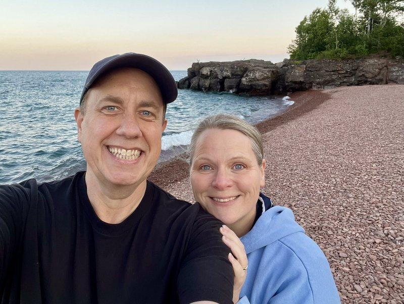 Justin and Jody taking a selfie above the pink rhyolite cobbles of Iona's Beach at sunset