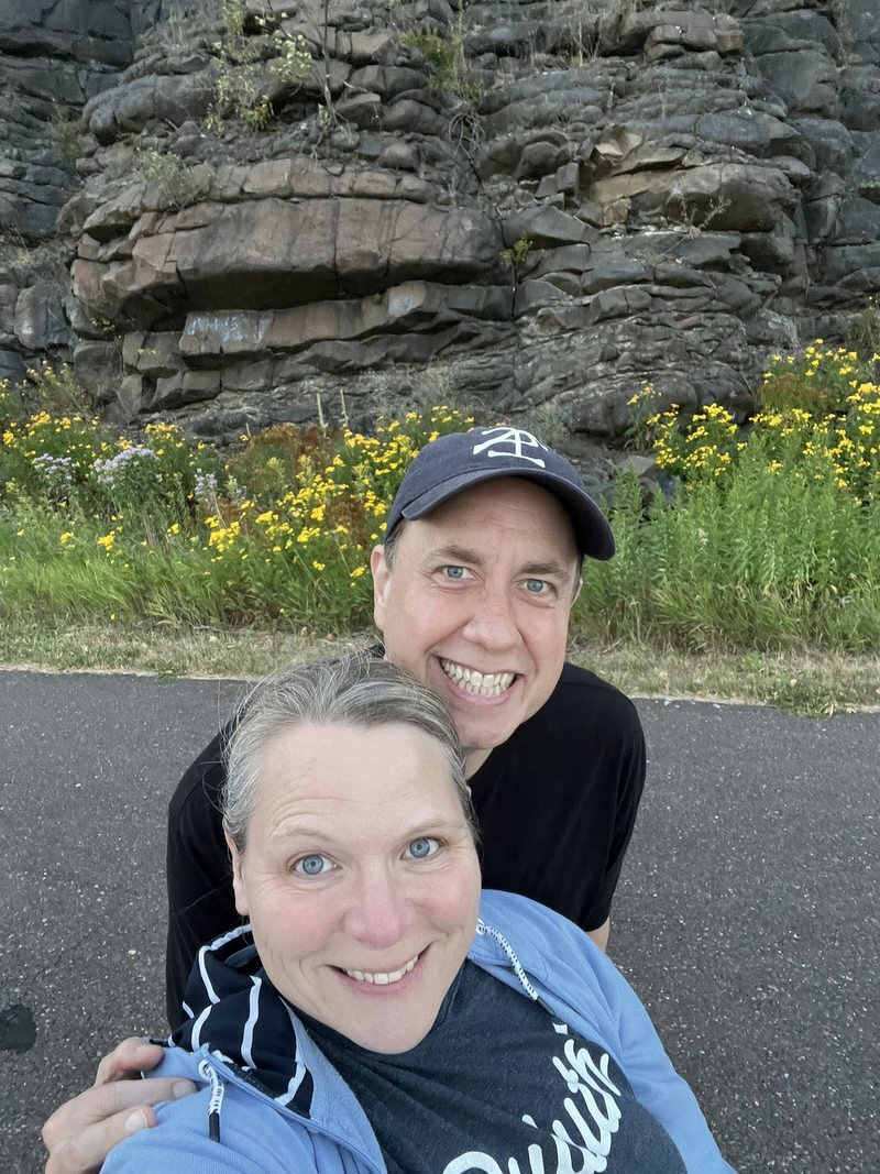 Jody and Justin on the trail back, a rock face and wildflowers behind them