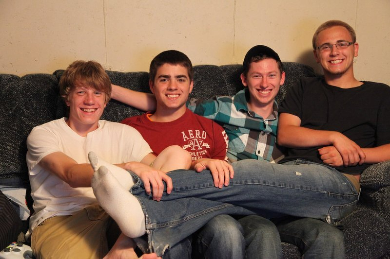 Alex and three friends piled together on a couch on their last guys night before college