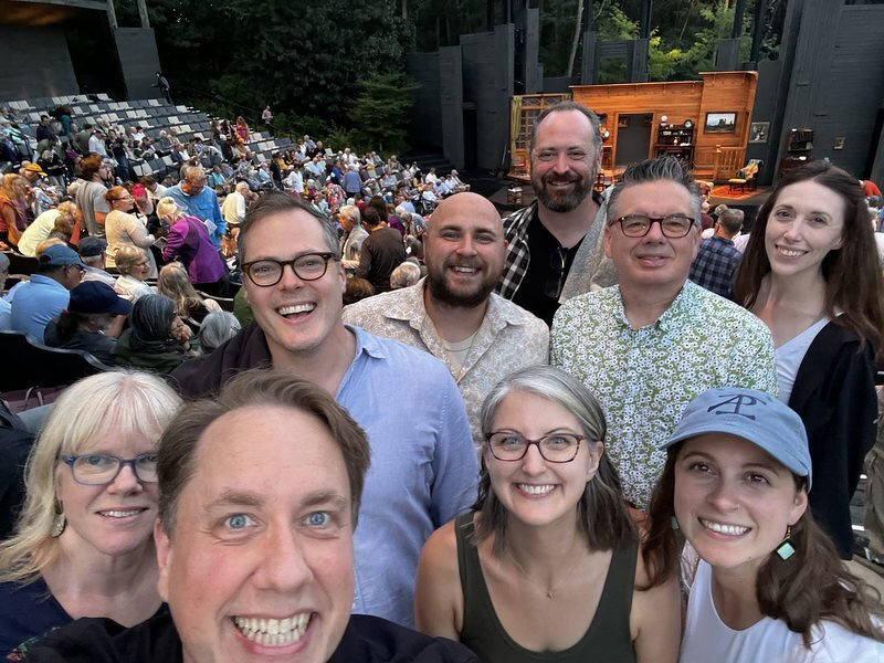 Another group selfie in the Hill Theatre with the amphitheater filling up behind them