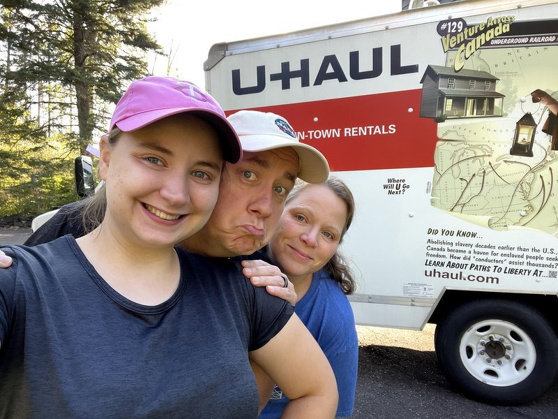 Kaylee, Justin, and Jody making faces in front of the loaded U-Haul