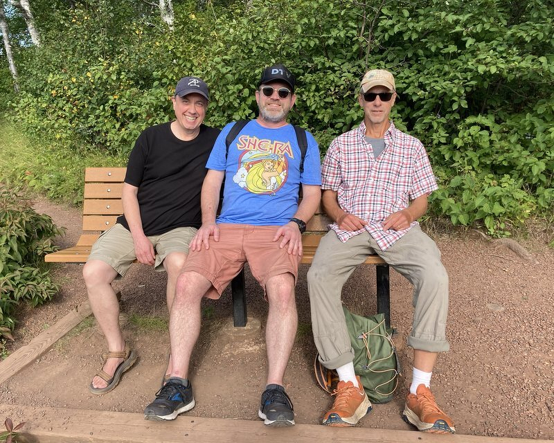 Justin, Robert, and John sitting on a bench along the trail