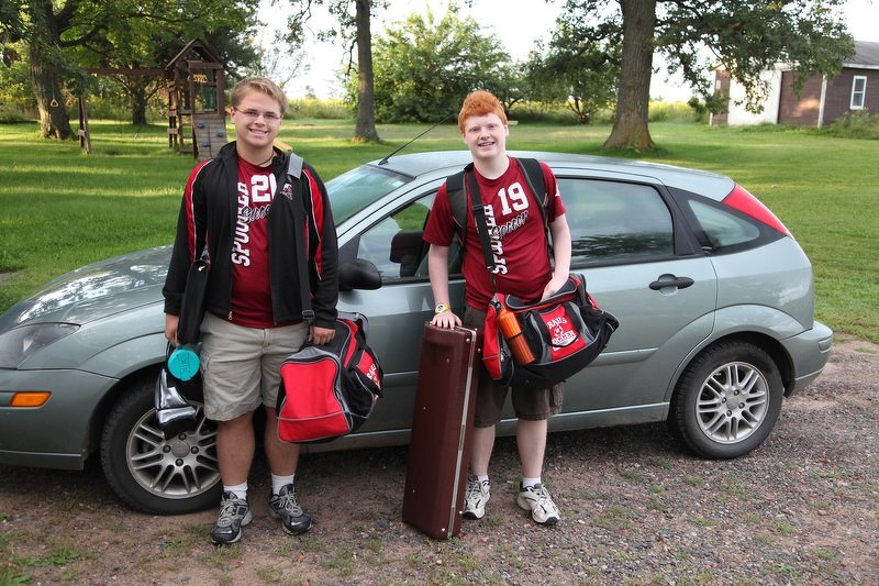 Spencer and Corey with backpacks and bags beside the car, ready to head off for the first day of school