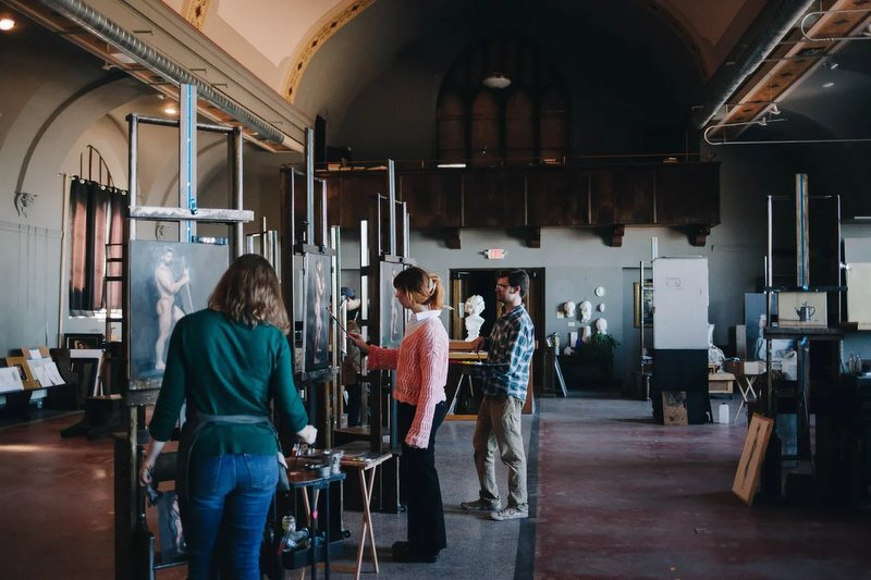 Students working at easels in the sunlit studio of the Great Lakes Academy of Fine Art