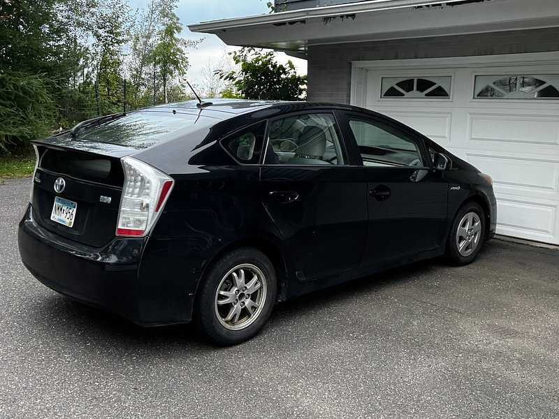 Our black Prius back home, parked in the driveway in front of the garage
