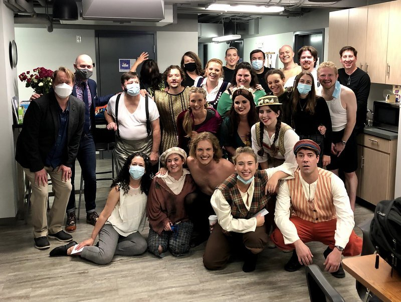 The Spamalot cast and crew crowded together backstage in the green room, some in costume and some in masks, all grinning