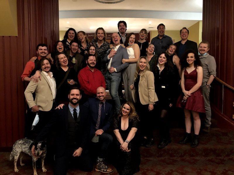 The Spamalot company dressed up and laughing on the NorShor lobby staircase on opening night, with Candy joining the group photo