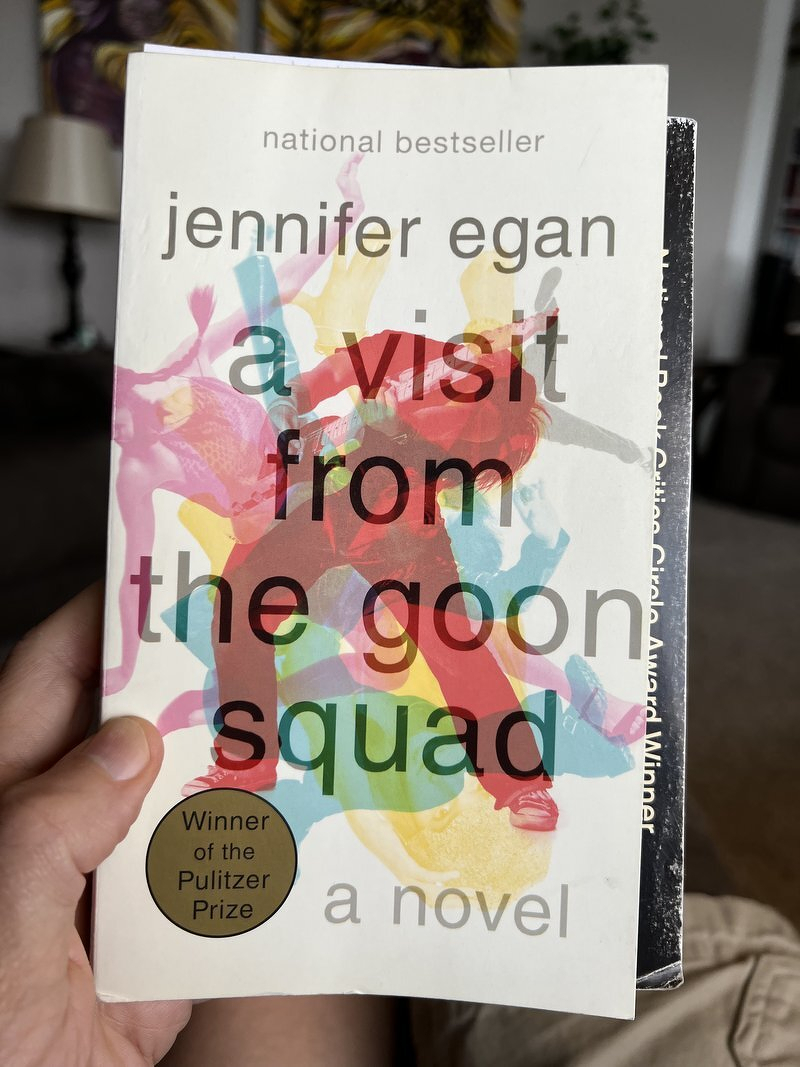 Holding up a well-worn paperback copy of A Visit From the Goon Squad by Jennifer Egan