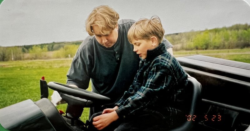Justin and Alex at the wheel of the riding lawn mower