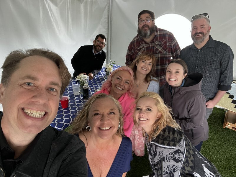 A selfie with a tableful of friends gathered under the reception tent