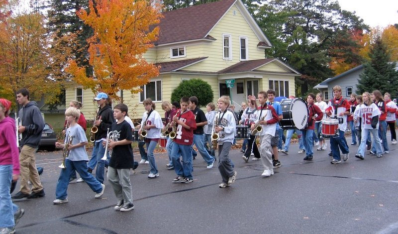 The middle school marching band in the 2006 homecoming parade, the bass drum riding high in the middle of the horn line