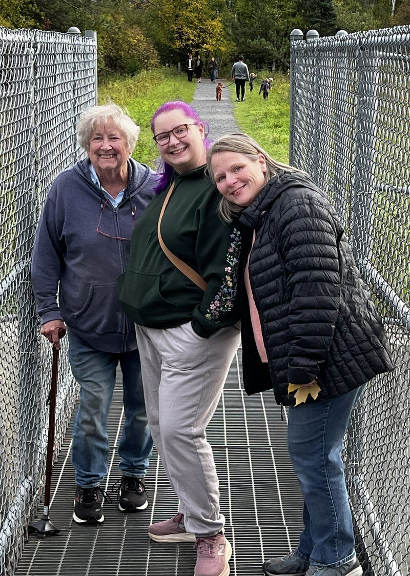 Mom, Kaylee, and Jody posing on a fenced footbridge along the Hartley trail