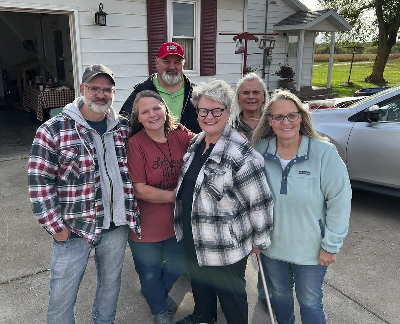 Jody and her siblings posing together in the farmhouse driveway