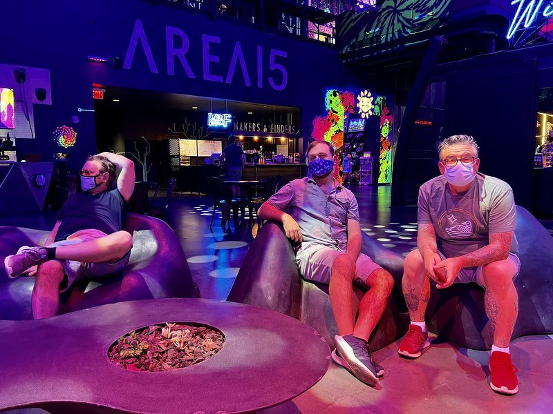 Daniel, Robert, and Jeff lounging under the AREA15 sign in Las Vegas