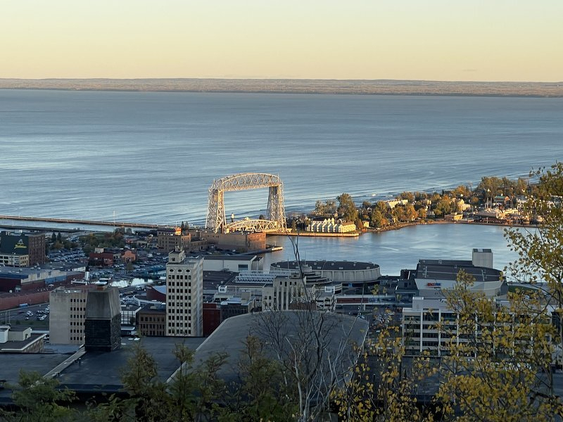 A view from the hilltop down to Canal Park, the Aerial Lift Bridge, and the curve of Minnesota Point stretching across Lake Superior