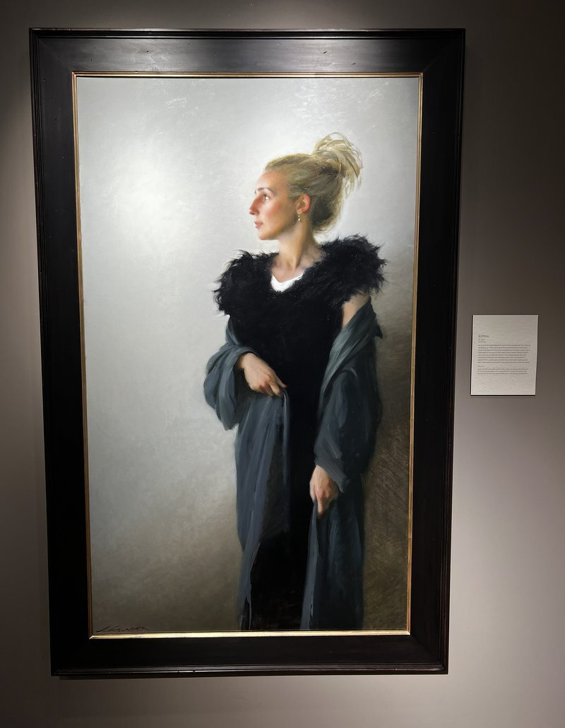 A Jeffrey Larson portrait of a blonde woman in a black feathered gown and gray wrap, gazing to the side