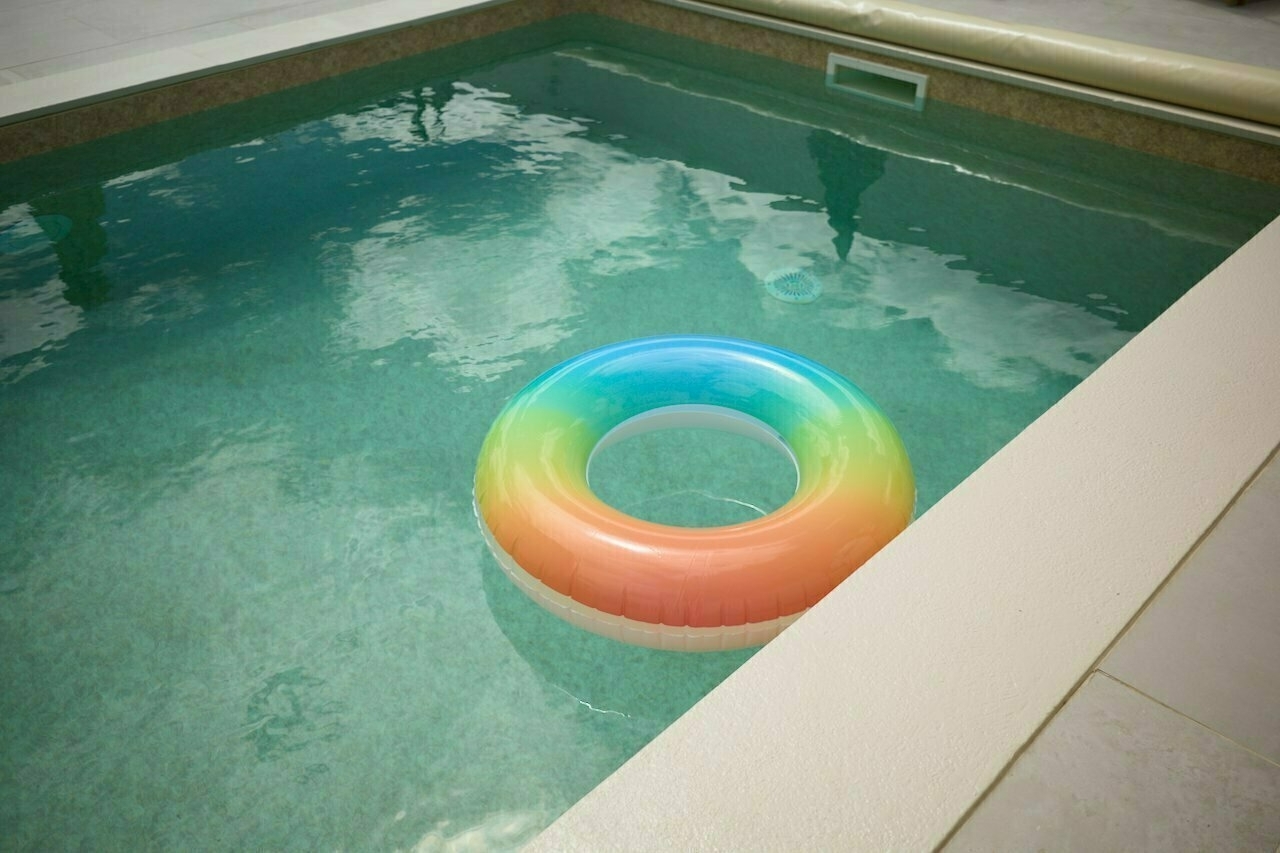 A colorful inflatable ring floats in a swimming pool.