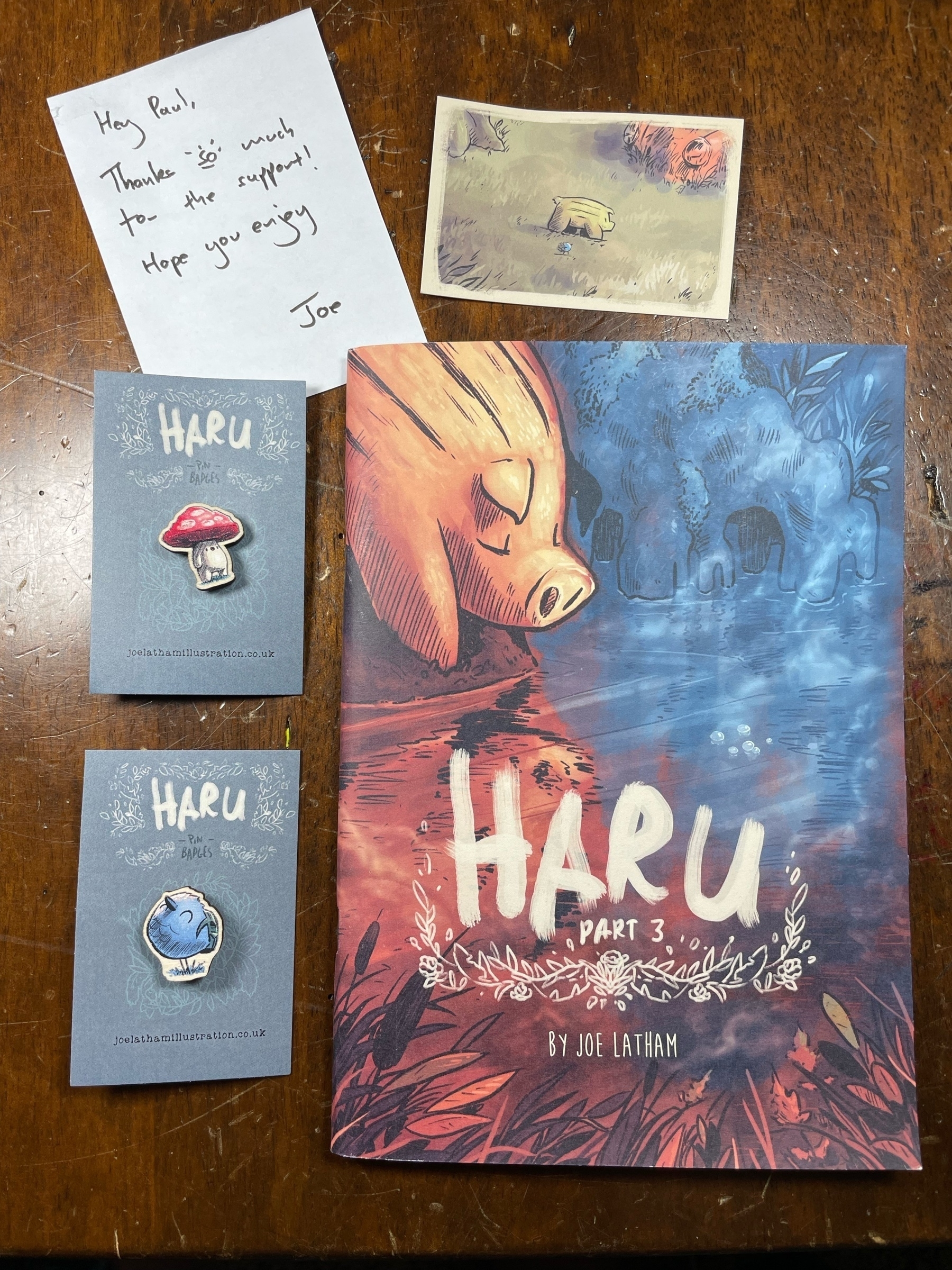 Issue 3 of Haru, two wooden character pins, a handwritten thank you note, and the backnof a business card depicting the character Yama
