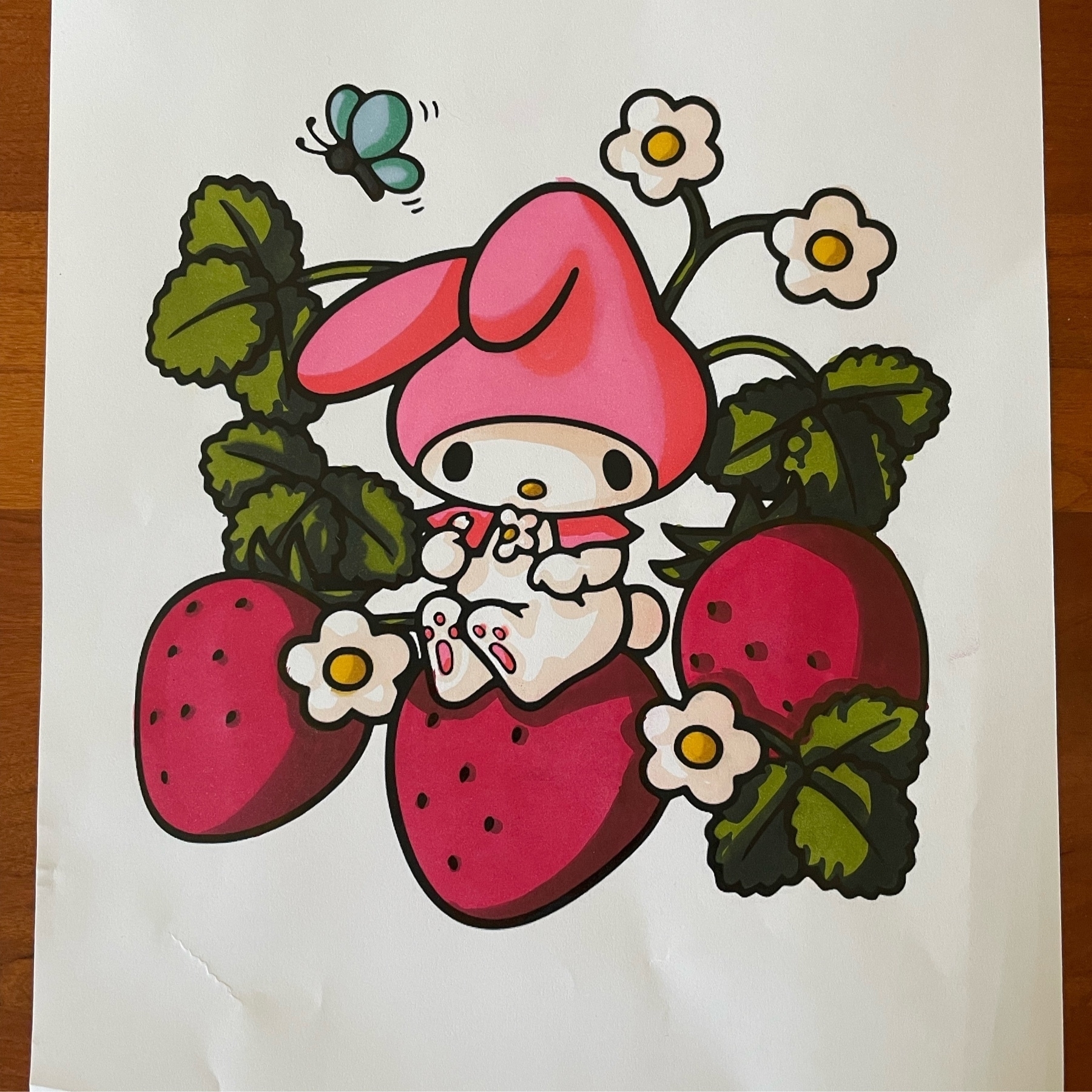 Tiny rabbit character sits atop some strawberries as an even smaller butterfly flies by
