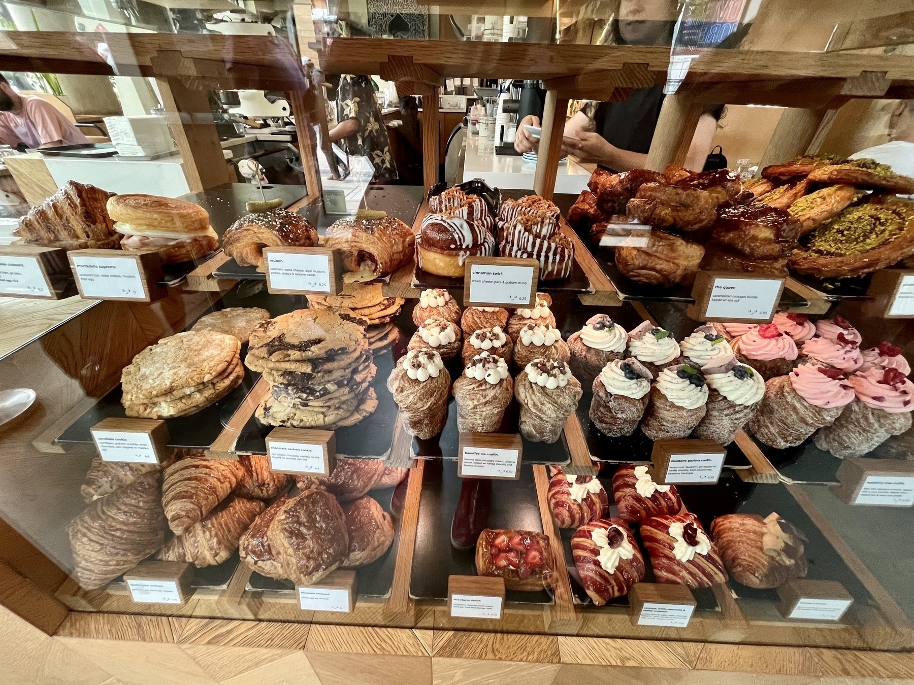 Wide angle photo of the glass display of pastries at the counter of Nemesis