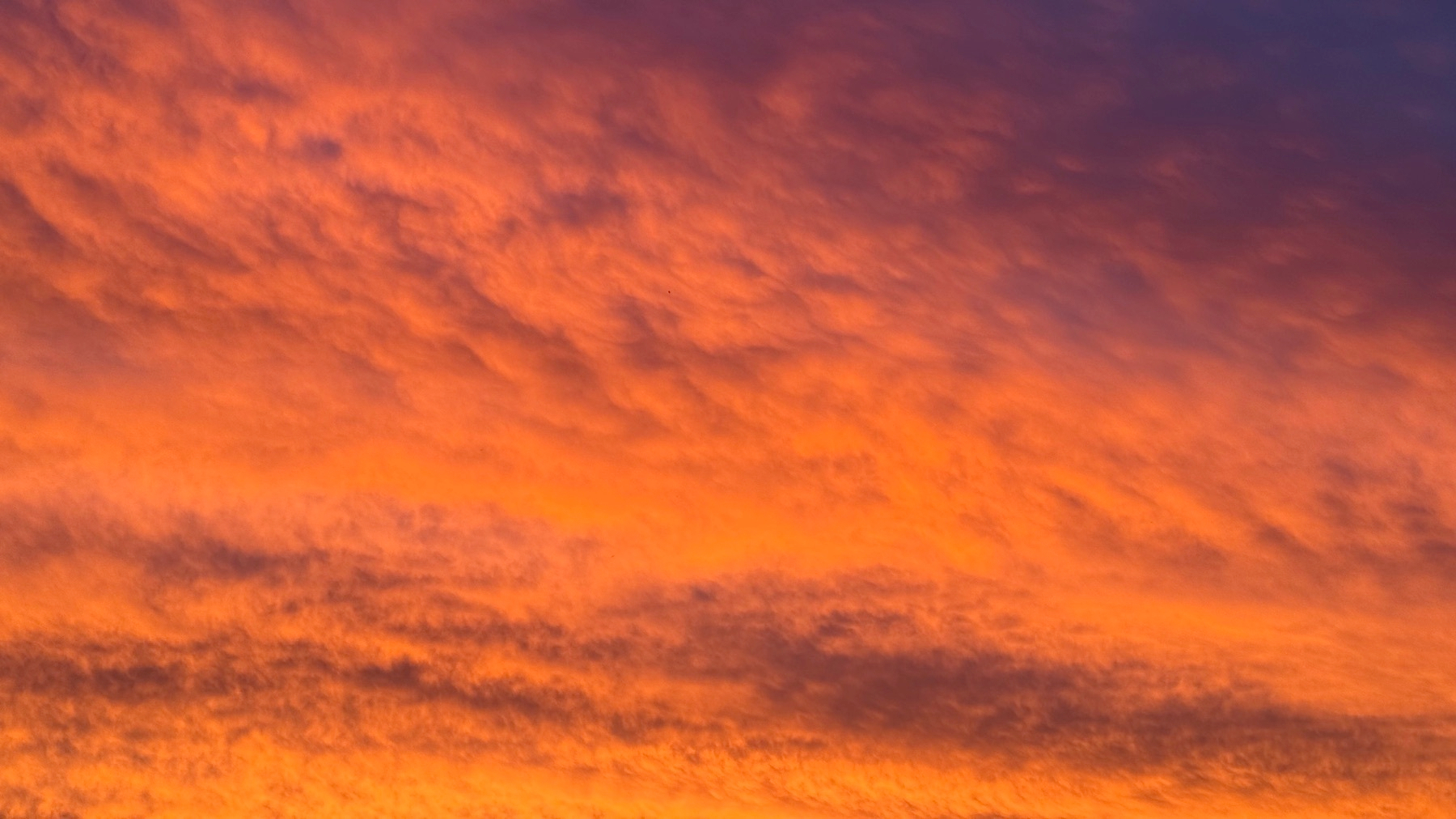 A vibrant, colorful sky displays hues of orange, pink, and purple during sunset.