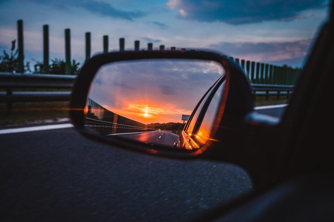 a rear view mirror reflecting a sunset in the side view mirror a rear view mirror reflecting a sunset in the side view mirror