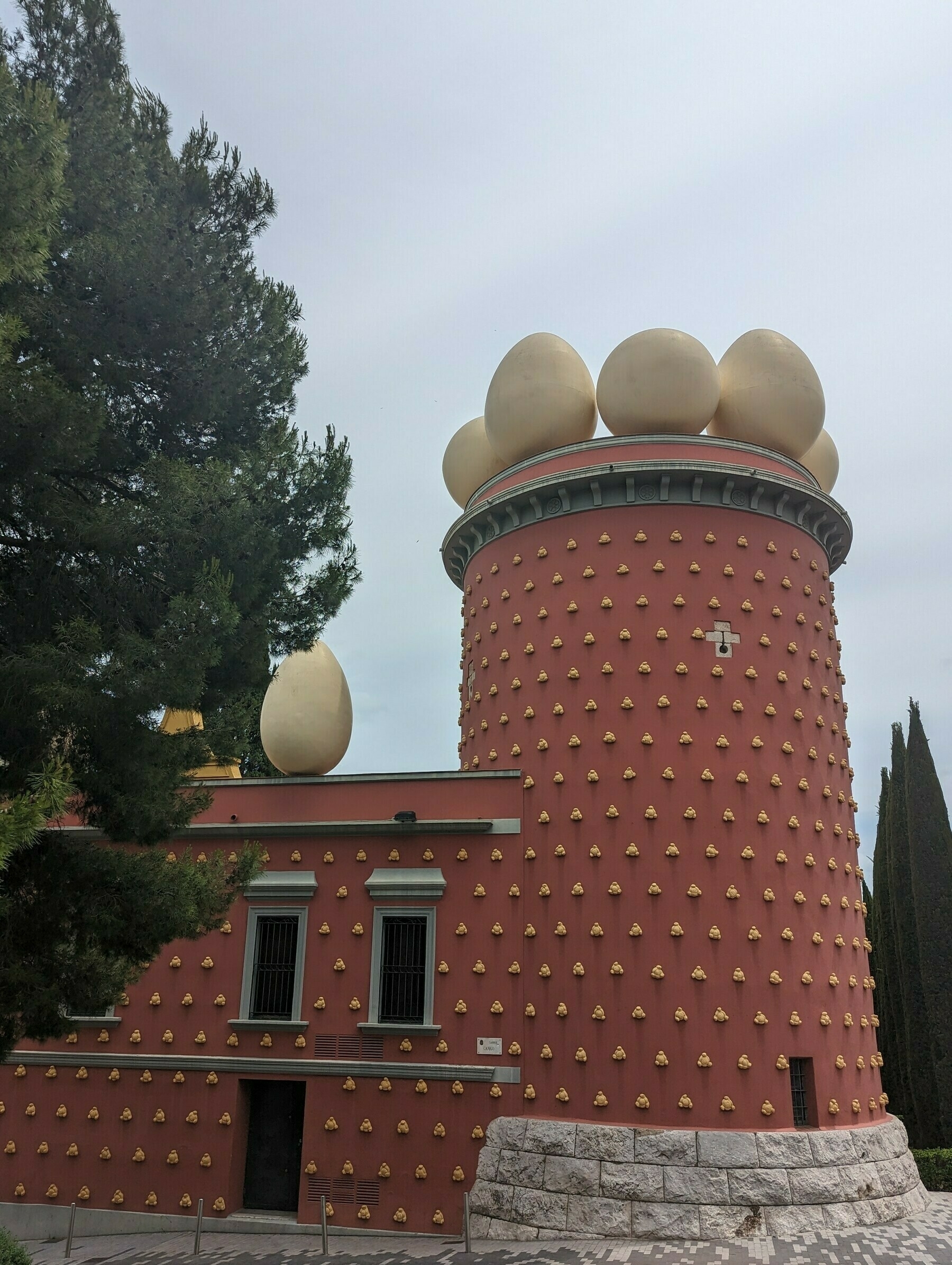 The maroon wall and tower of the Dalí Theatre and Museum building.