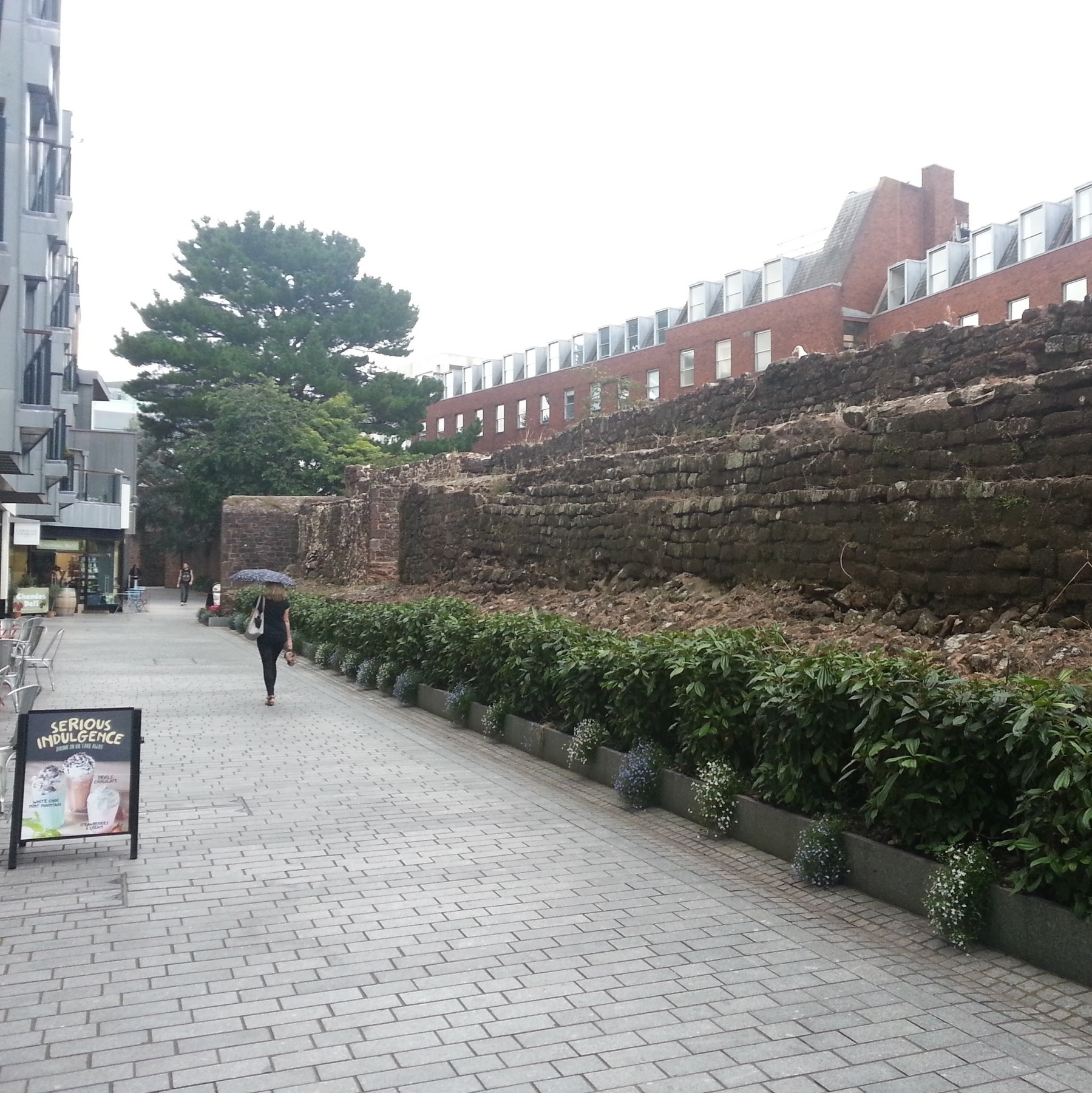 A Roman wall beside a modern footpath within Exeter.