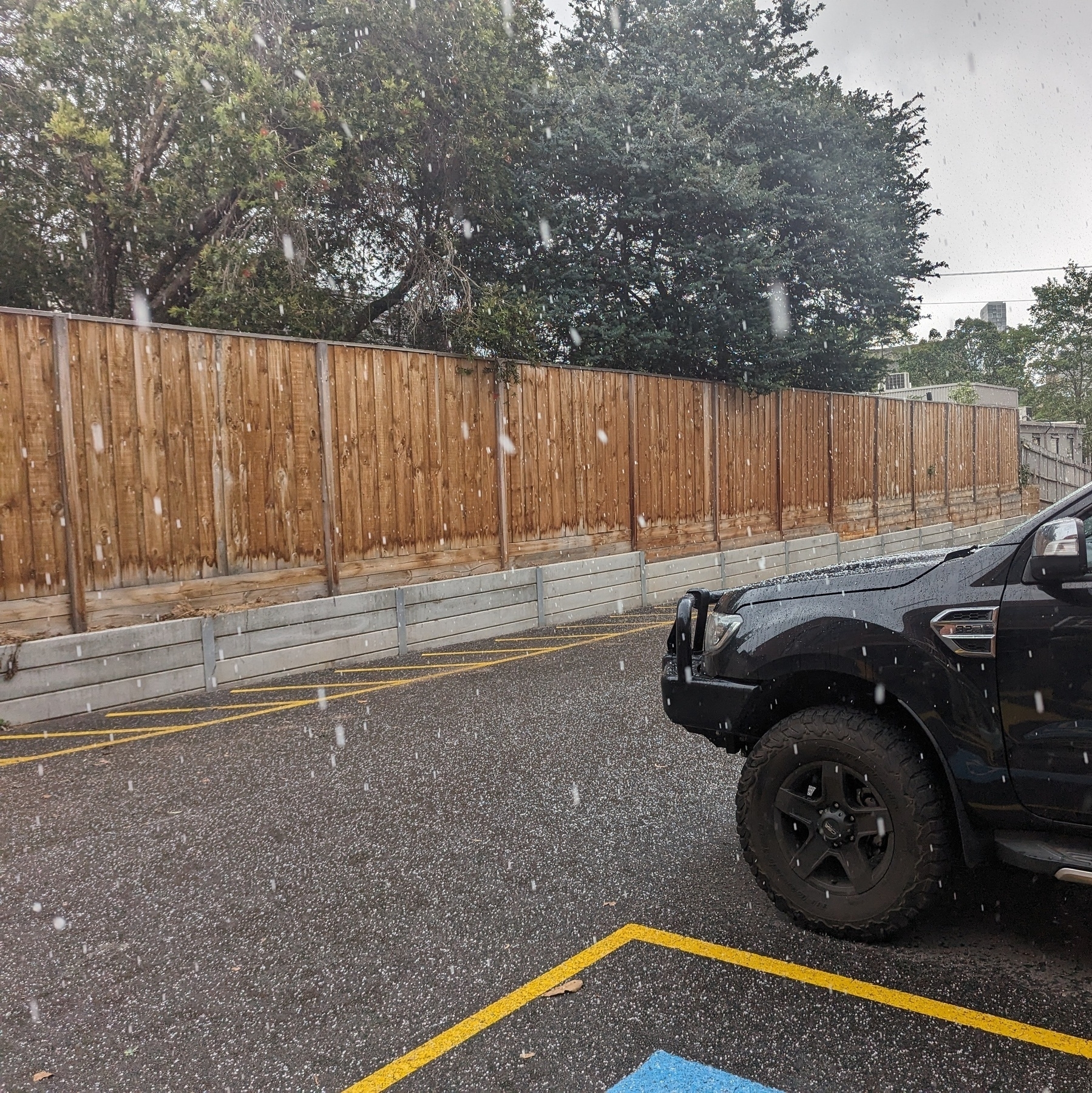Carpark with the front of a black 4WD in the hail