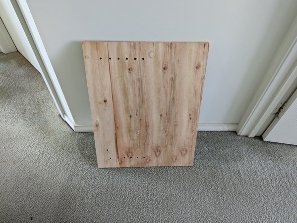 A wooden board propped up against a wall