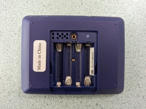 Rear of the SMART Response XE, with the back cover removed showing the battery compartment and the holes used to reprogram the device